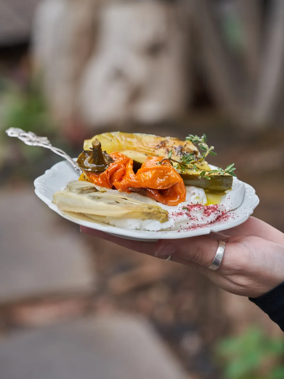 A colourful plate of roasted vegetables and white cream on a table at The Belina